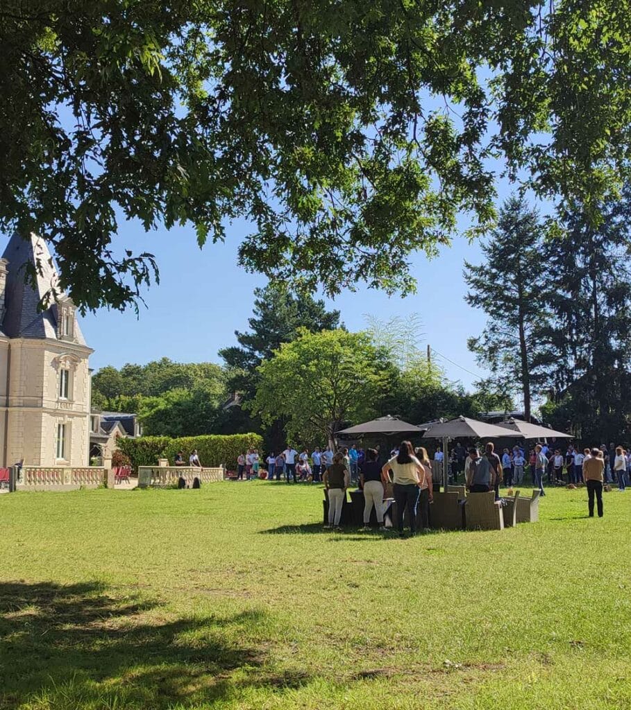 Participants rassemblés en plein air pour un séminaire au Château Le Saz